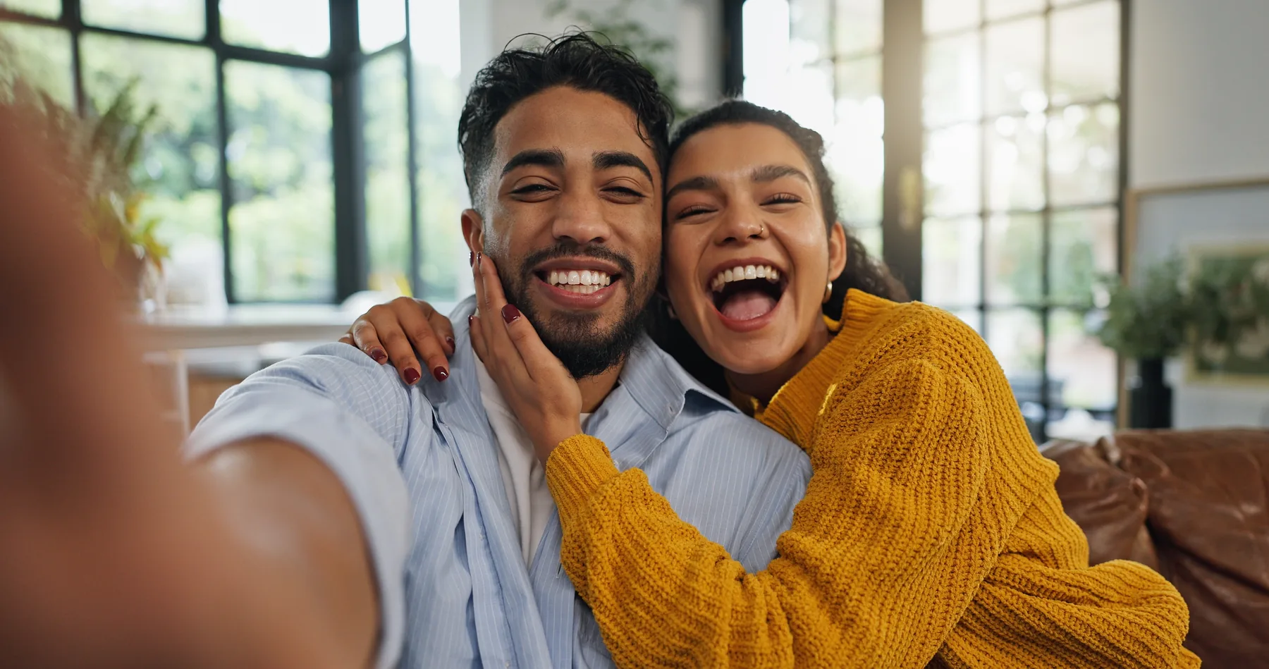 Smiling couple taking a selfie at home