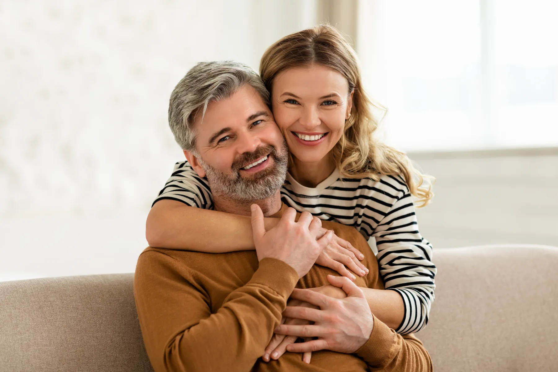 Smiling family sitting together on a couch