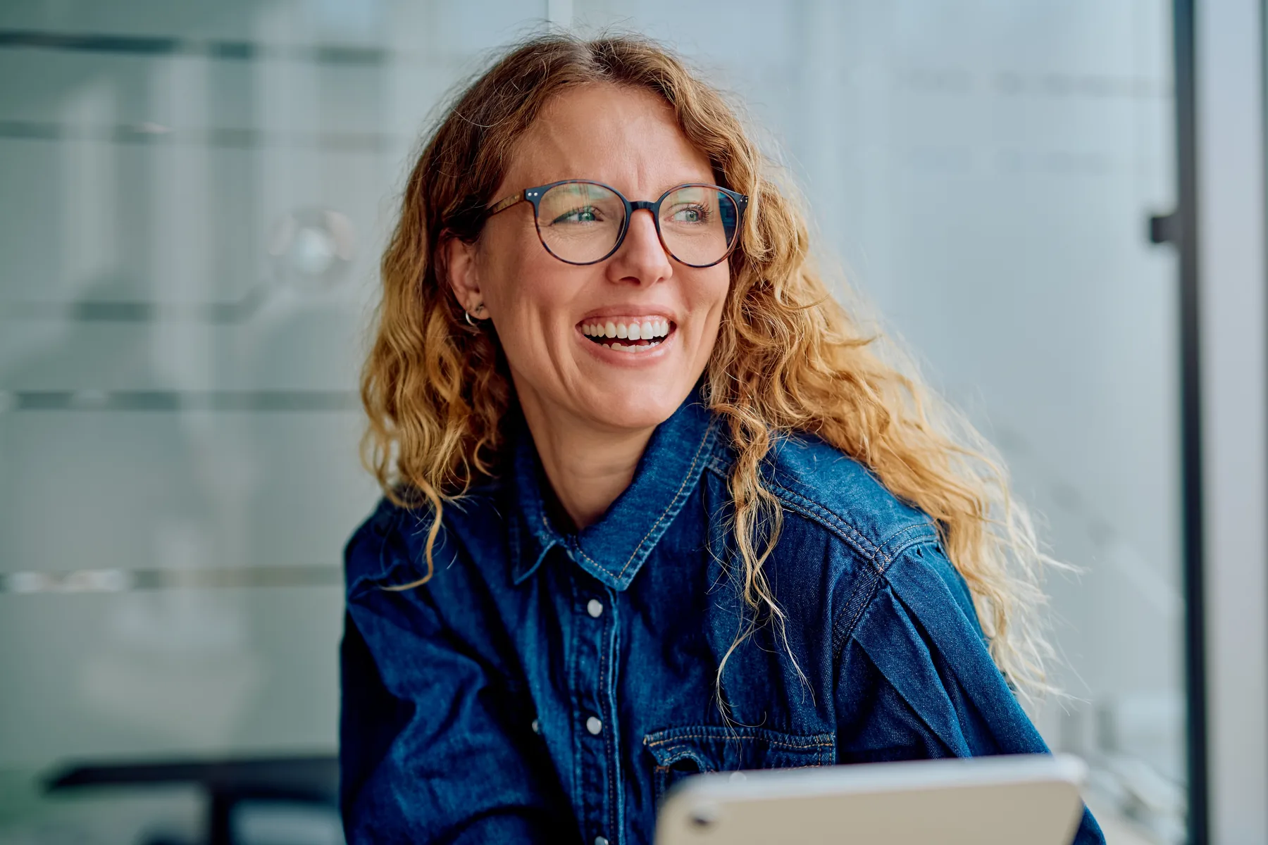 A smiling woman in glasses, selected from the Harwood Family Dental Source Library